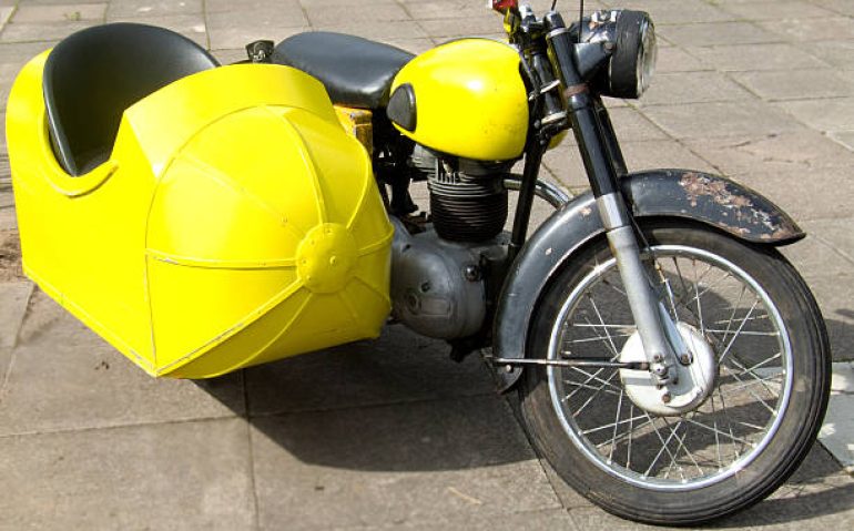 Vintage motorbike with bright yellow side car.
